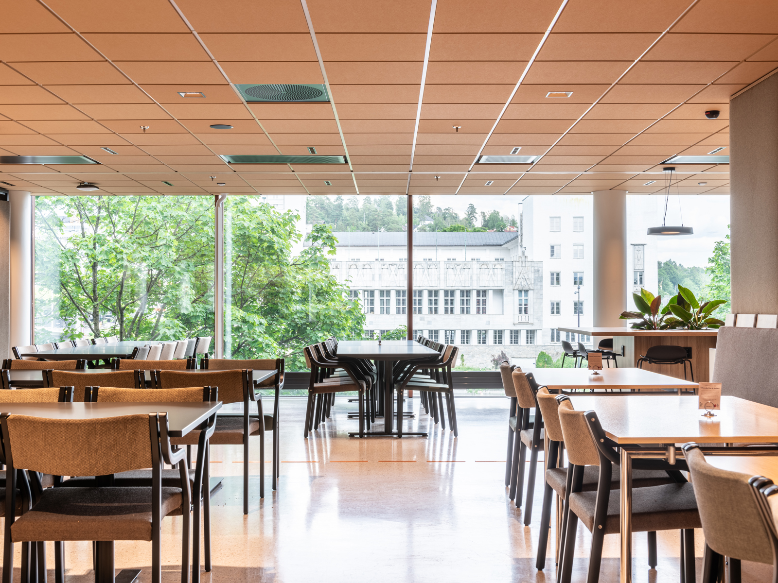 Sittegrupper md bord og stoler, store vindu i fasaden. Interiør foto.