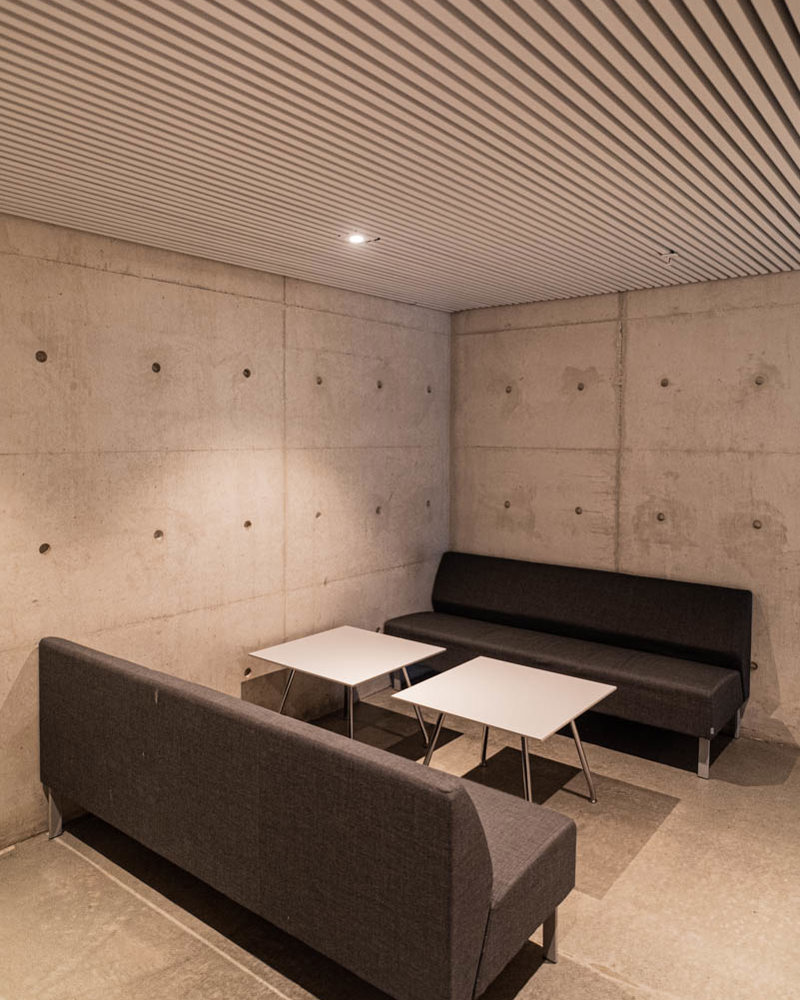 Interiør foto, betong vegger og gulv, sittegruppe med sofaer.