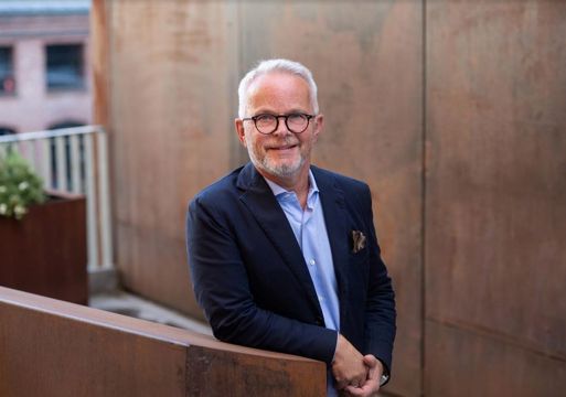 Gunnar Bøyum lener seg på en kant av corten stål. Foto.