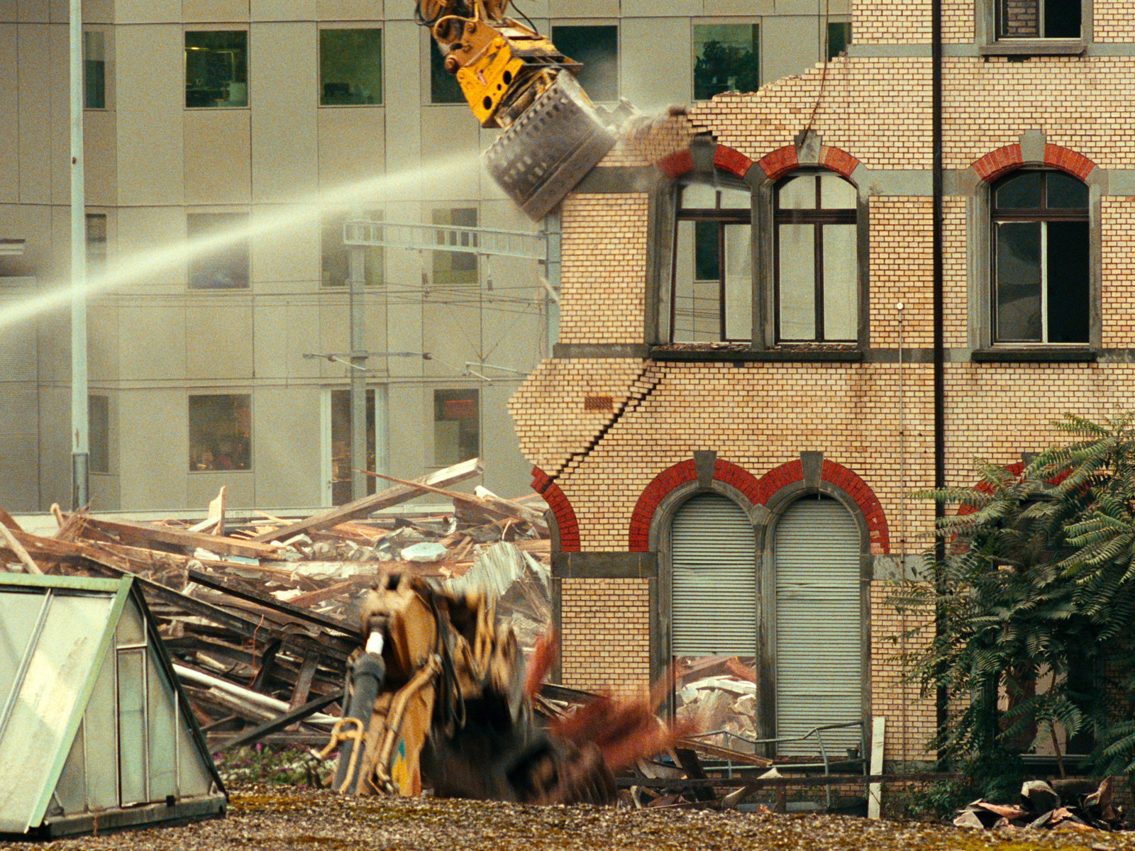 Stillbilde fra filmen "Nemesis" som viser et fint murbygg som blir revet.