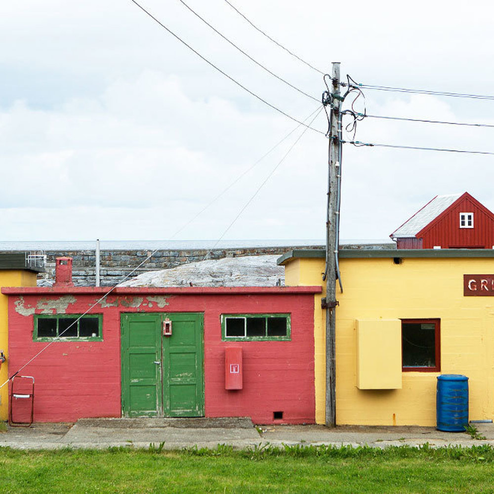 Tre sterkt fargede små betongbygninger