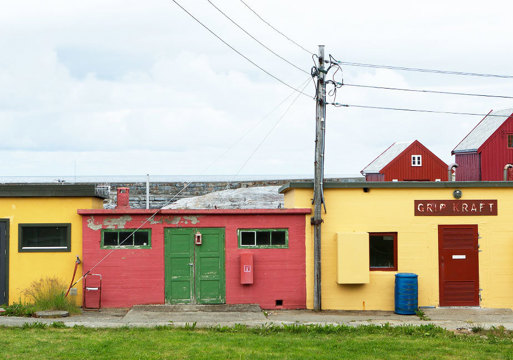 Tre sterkt fargede små betongbygninger