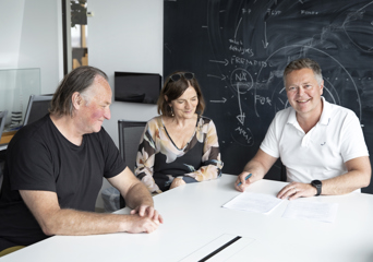 3 mennesker signerer en kontrakt. Foto.
