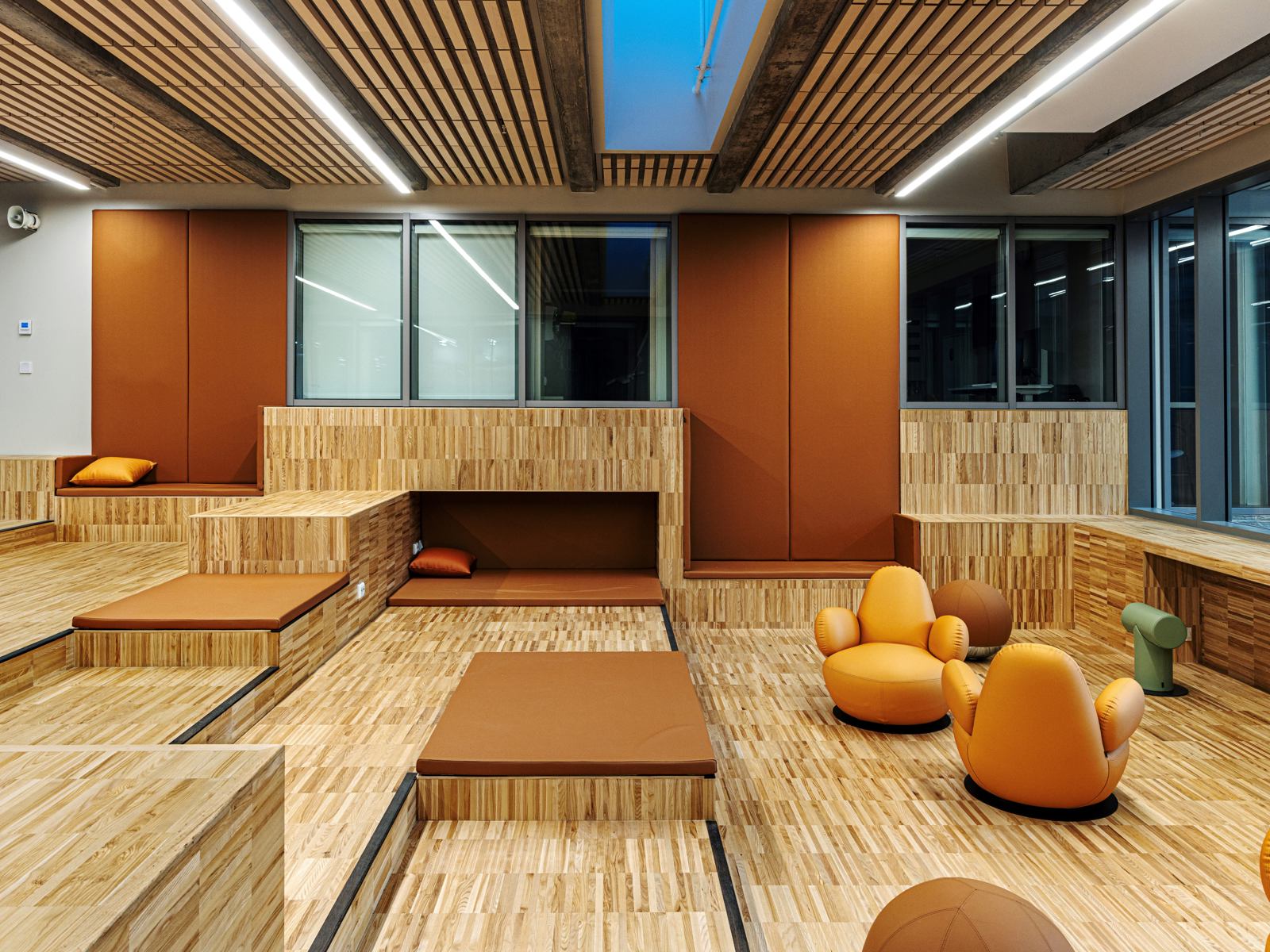 Interiør foto av oppholdsrom i sykehuskomplekset Glasblokkene, varme farger og treverk.