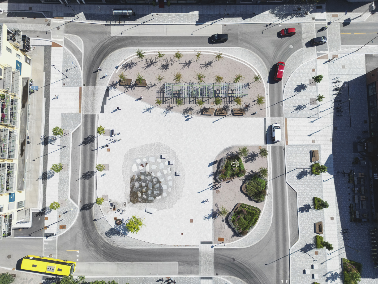 Oversiktsbilde av torg omsluttet av vei og bykontekst, liggende ved havet og bro. Drone foto.