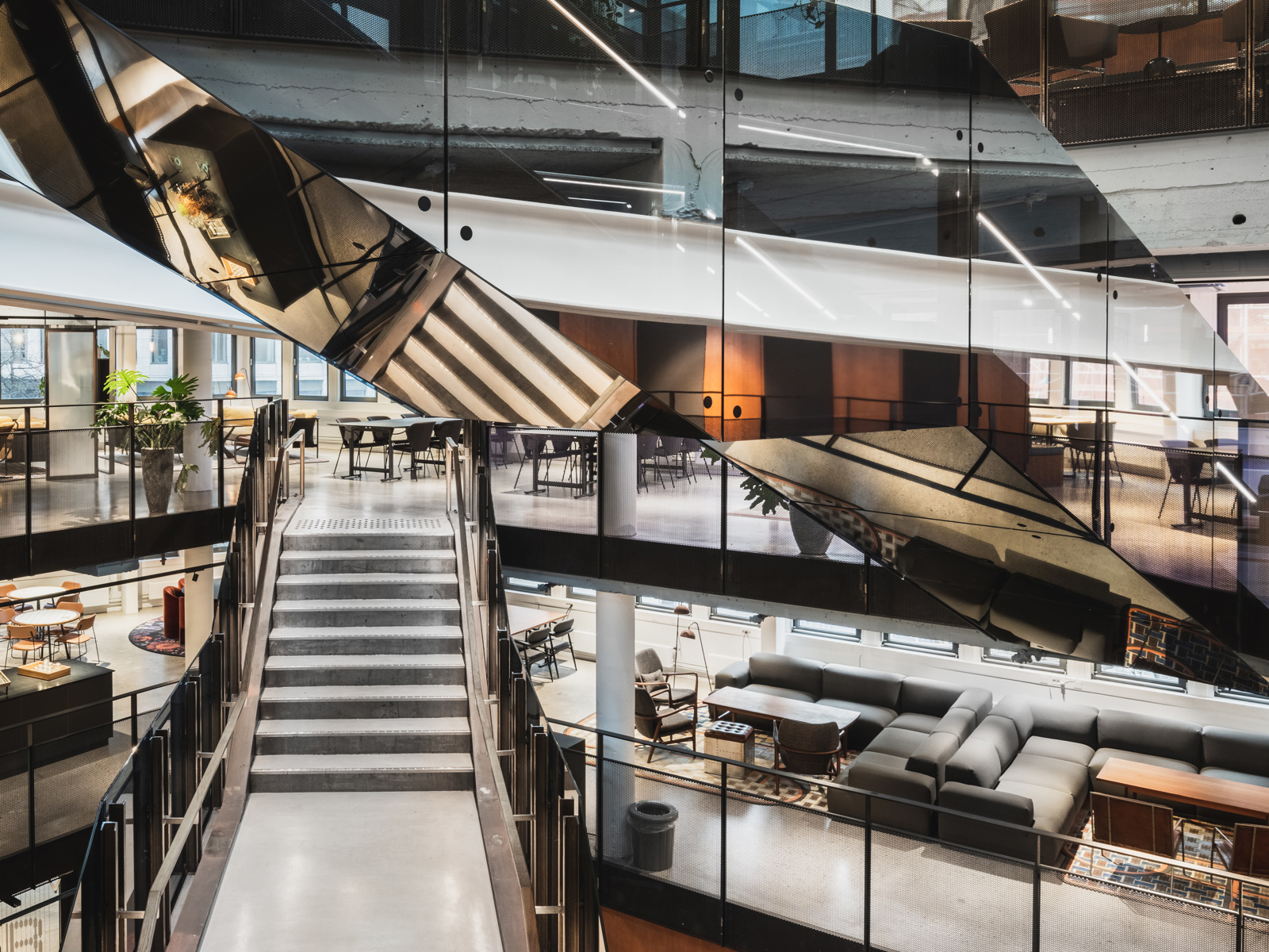 Interiør foto av stort trapperom og utsikt til flere ulike etasjer, reflekterende trappegelender.