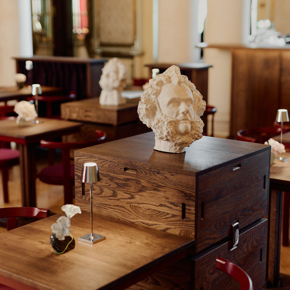 Podier som kan plasseres ulike steder i rommet gjør møbleringen fleksibel. Stolene er innkjøpt for prosjektet fra Magnus Olesen og spinner videre på den teaterøde fargen.