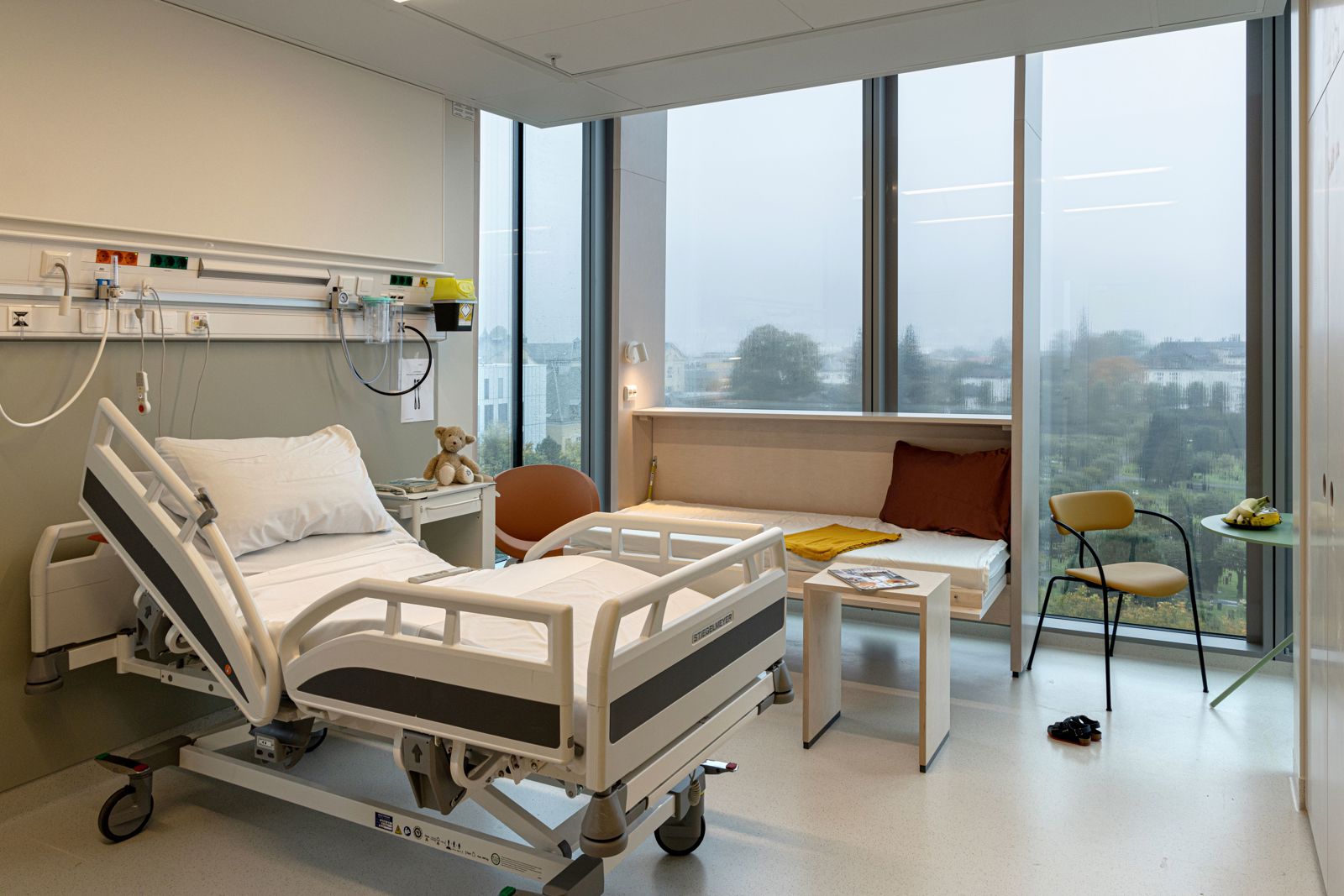 Interiør foto av sykehusrom i Glasblokkene, store vindusflater og sykehusseng.