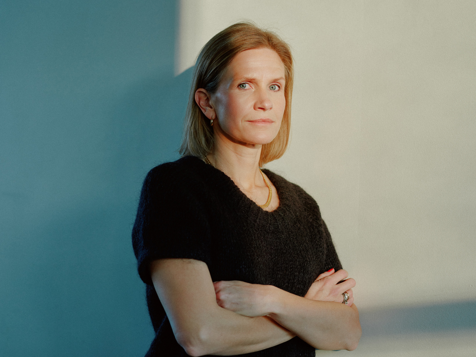 Portrett foto av Inger Therese Hoff som lener seg inntil en vegg.