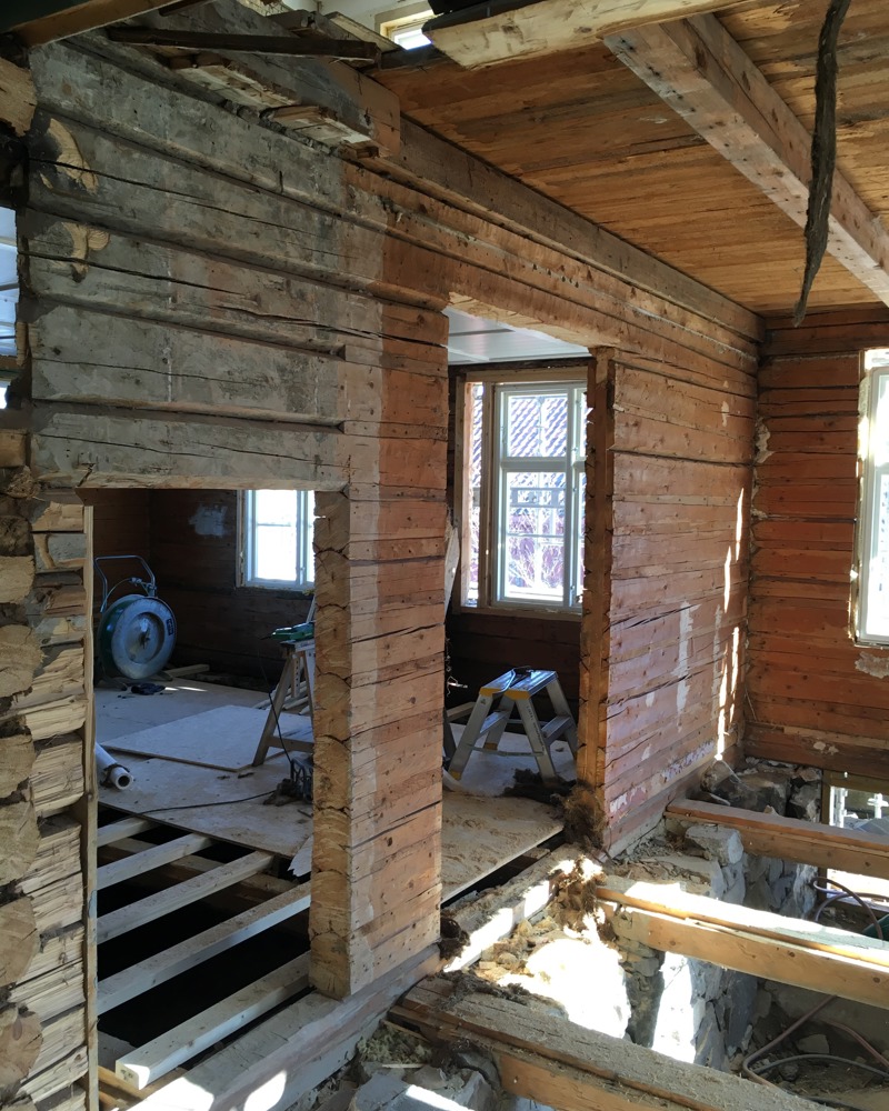 Interiør foto fra byggeplass, eldre laftet bygg, døråpninger. 
