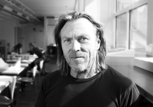 Svart hvitt foto av Herman Fuglu, kontorlandskap i bakgrunnen.