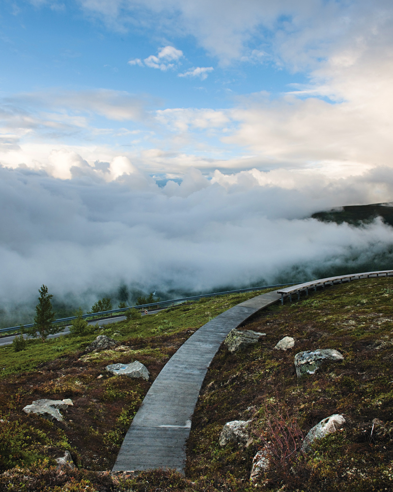 Foto av sti og benk som slynger seg rundt i fjell landskapet.