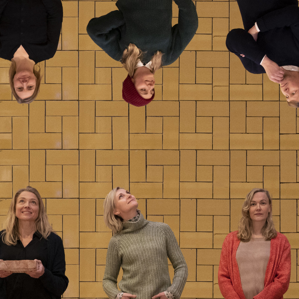 Ti personer foran en gul vegg