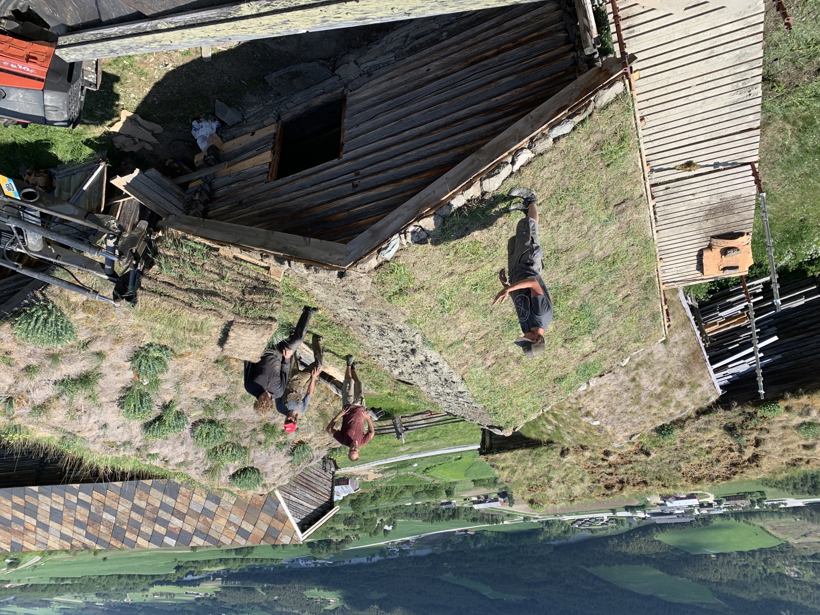 Foto av fire menn som jobber med å legge torv på et tak.