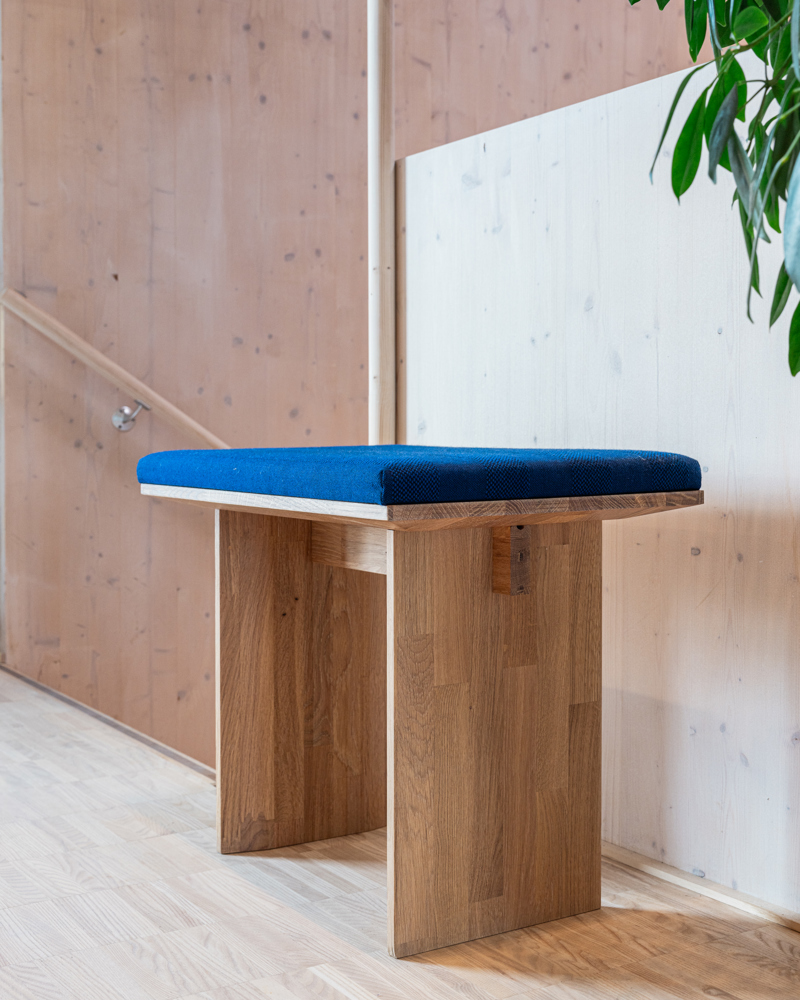 Produkt foto av krakk i treverk med blå pute.