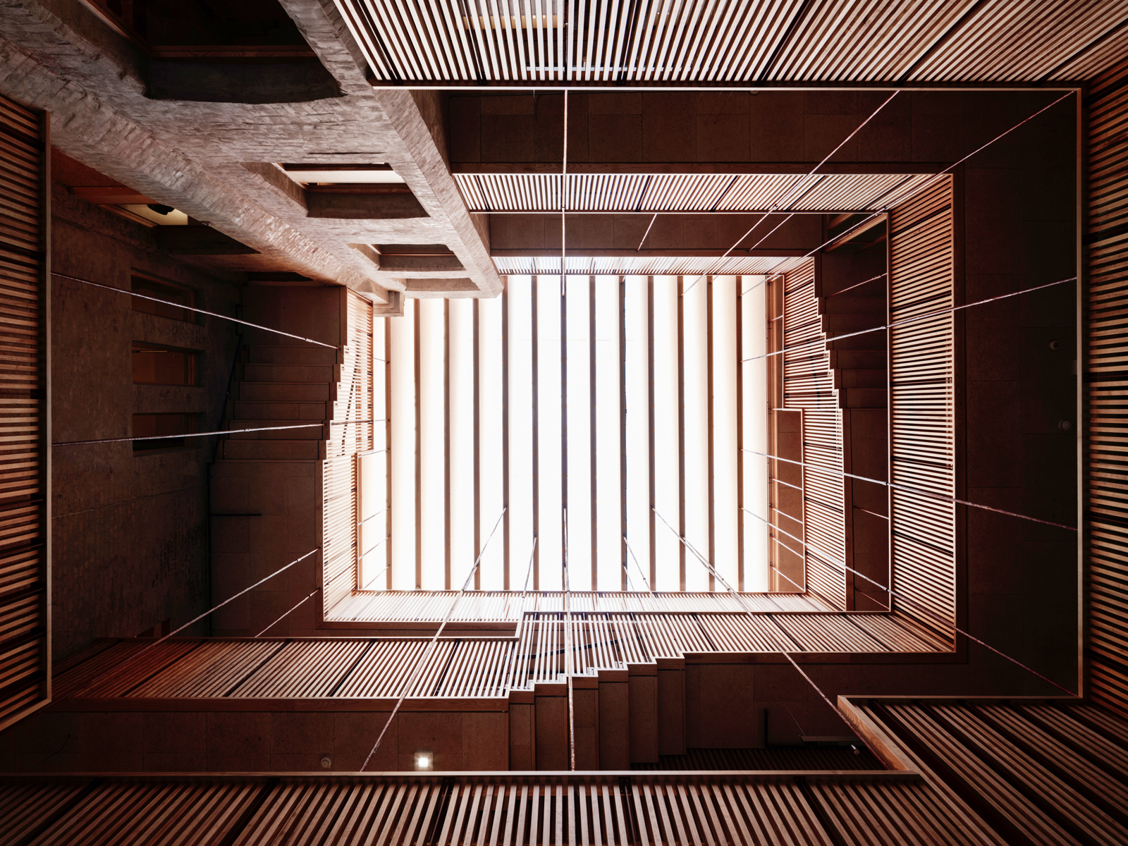 Fotografi opp i innvendig atrium med overlys. Atriumet er omringet av svalganer. Foto.