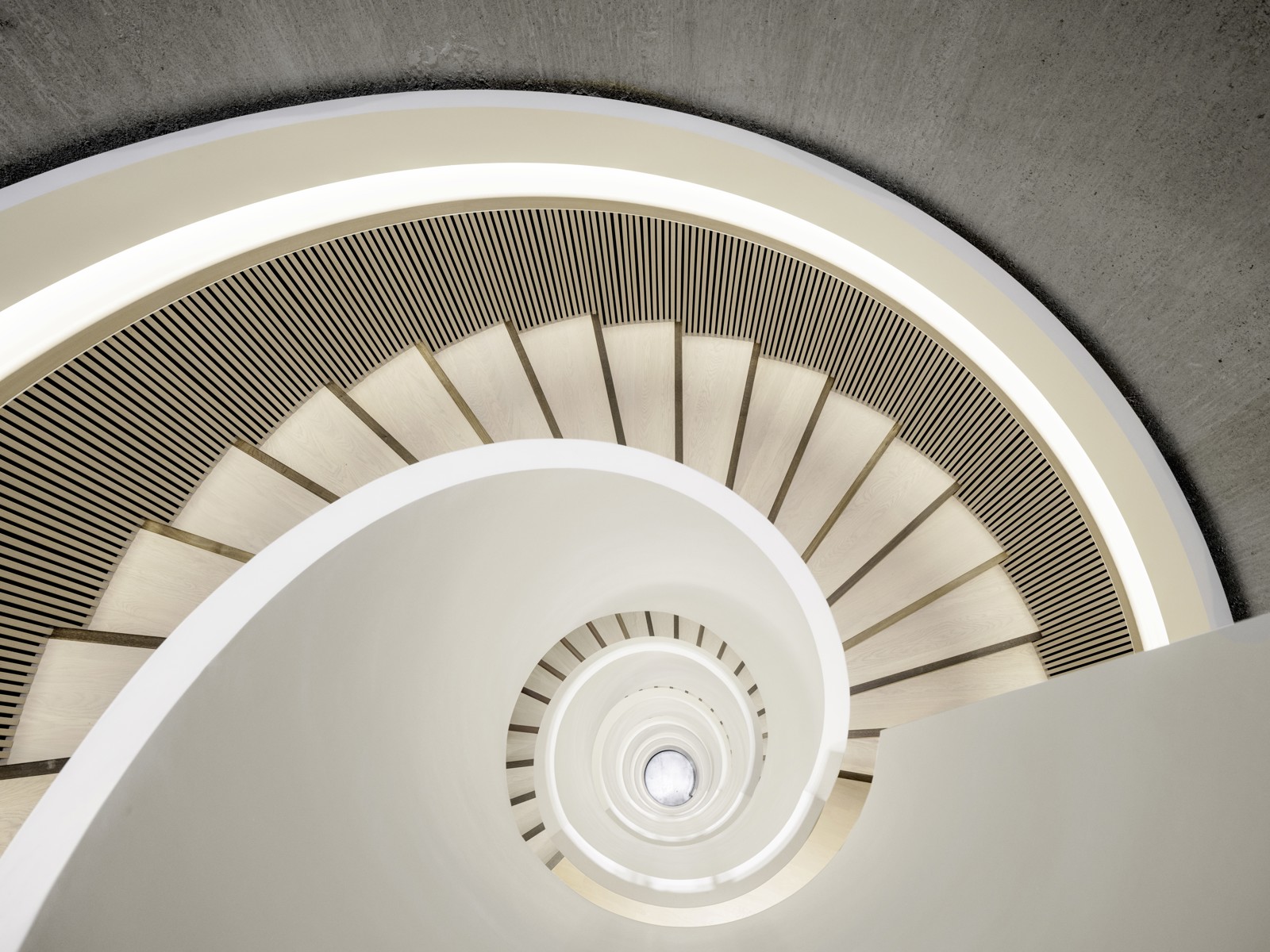 Interiør foto ned en hvit spiraltrapp.