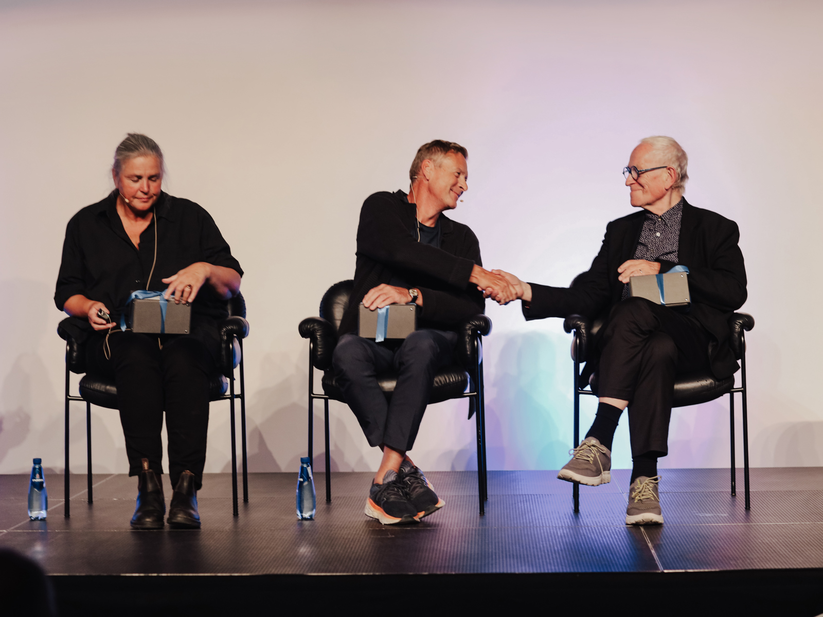 Foto av tre arkitekter på en scene