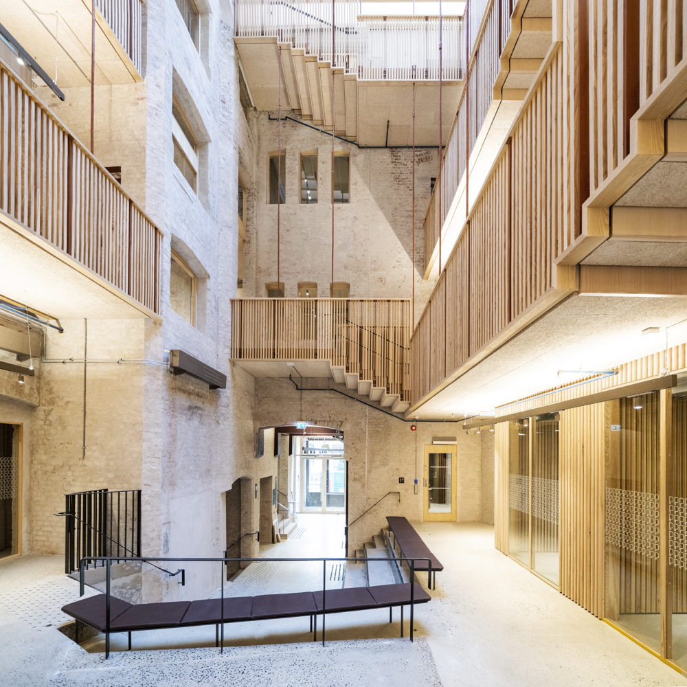 Interiør, innvendig atrium mellom eldre bygårdsbygg. Svalganger går rundt atriumet. Foto.