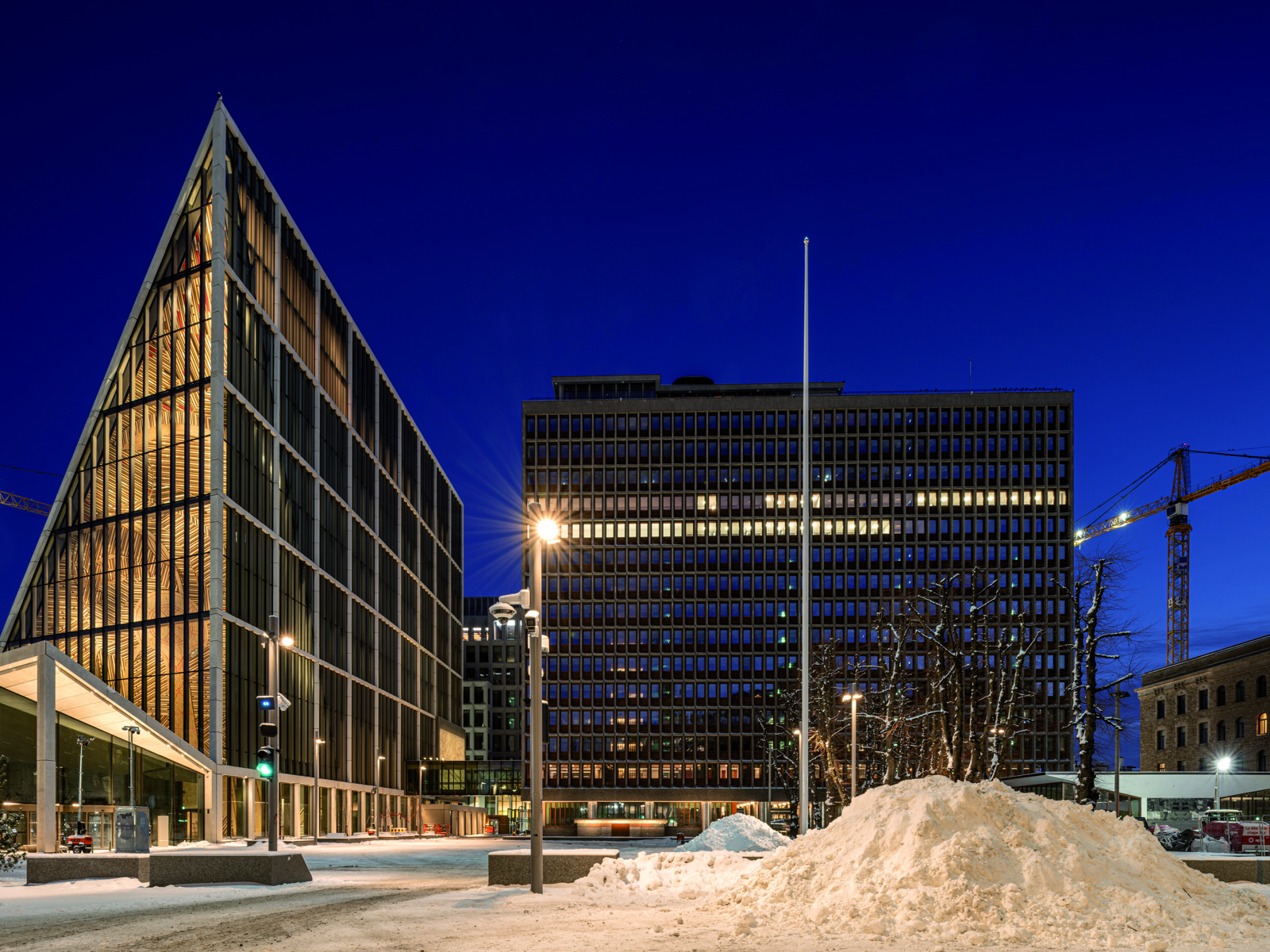 Foto av regjeringskvartalet tatt på vinteren med mørk himmel.