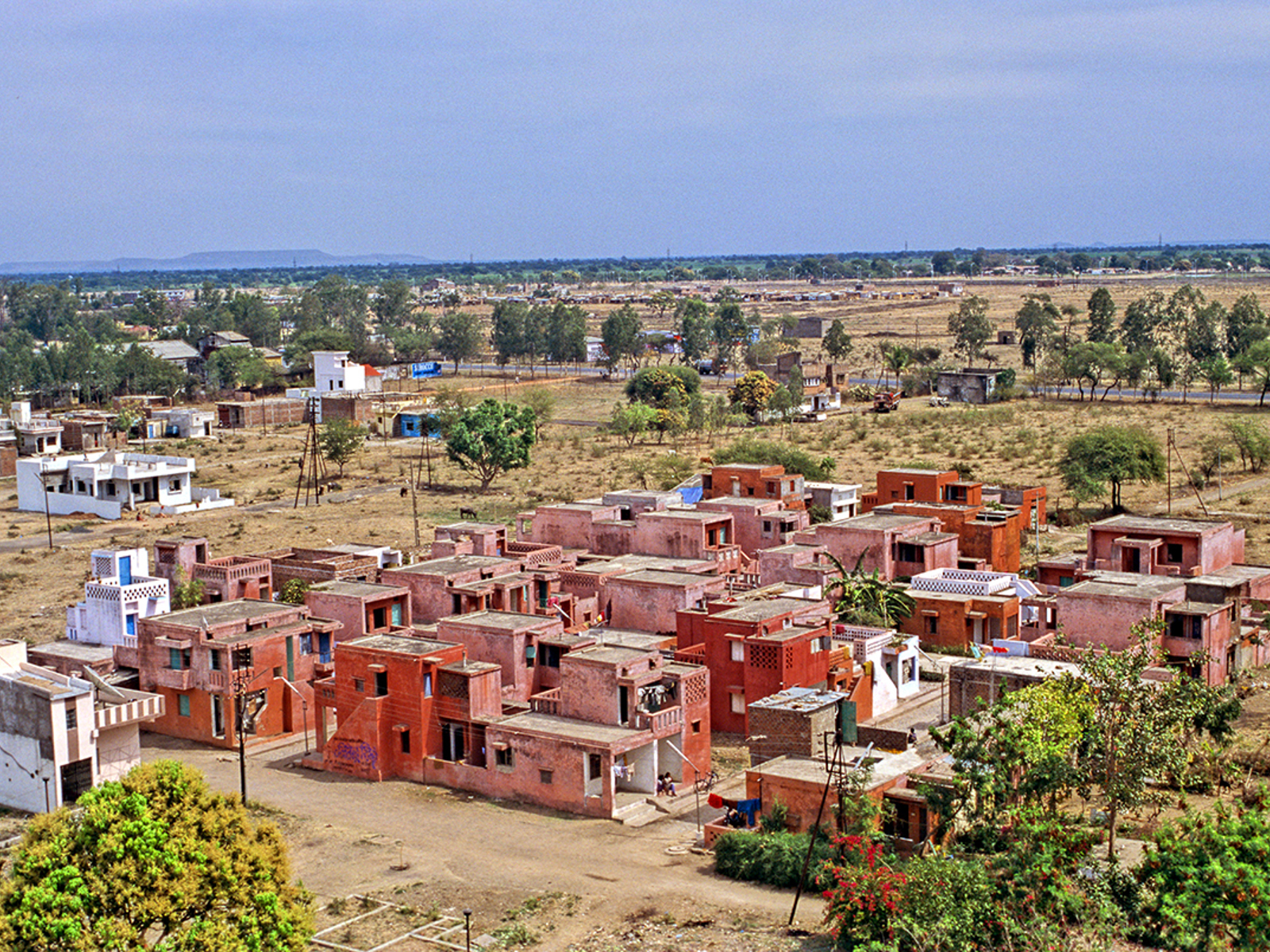 Sosial boligprosjekt i Aranya, røde hus og åpne gårdsrom. Foto.