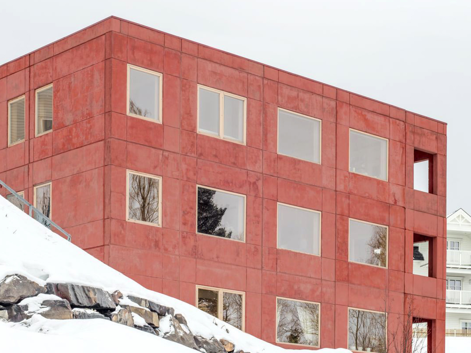 Rødt murbygg i snøen