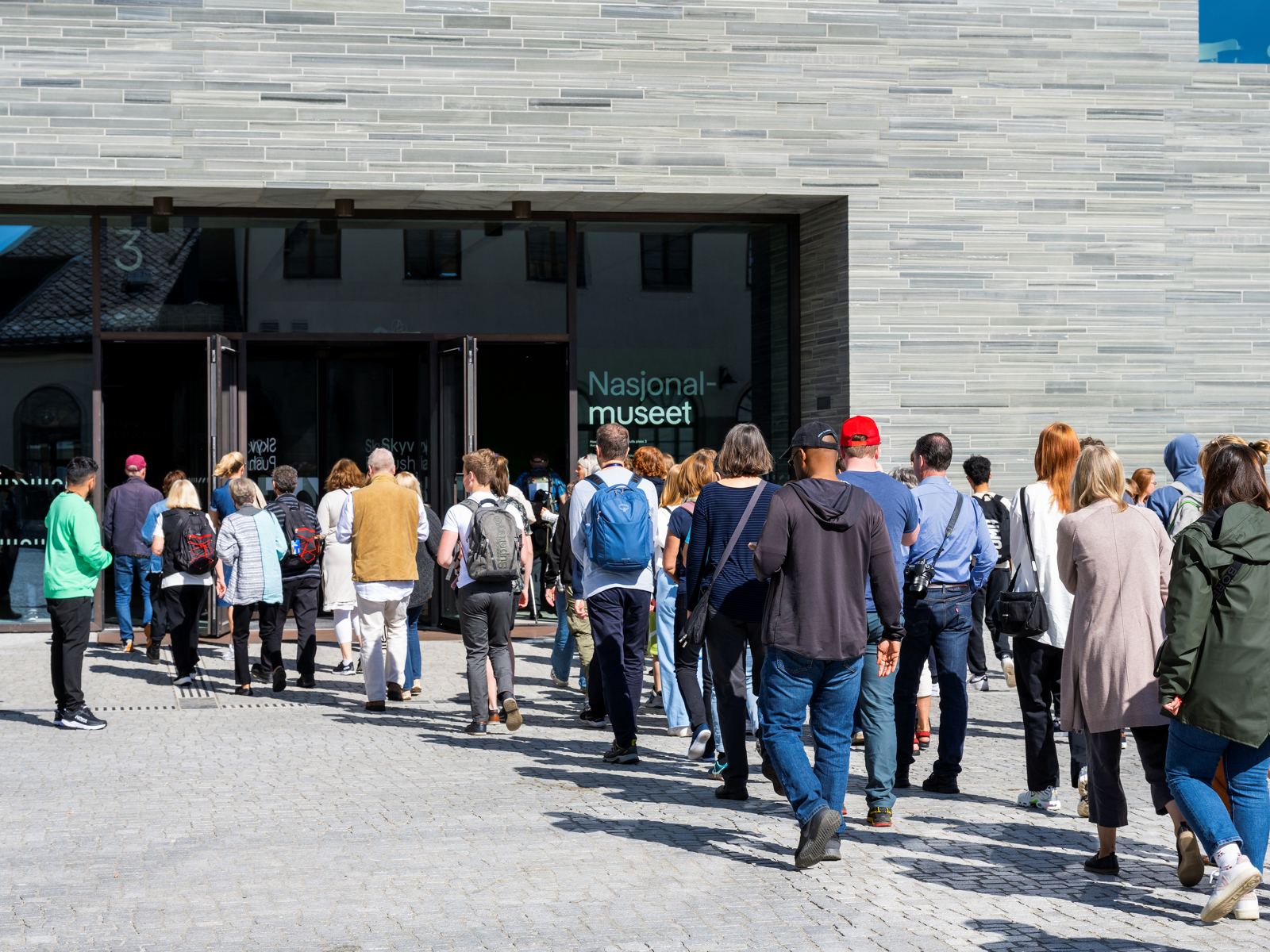 Mennesker i kø utenfor inngangen til Nasjonalmuseet i Oslo.