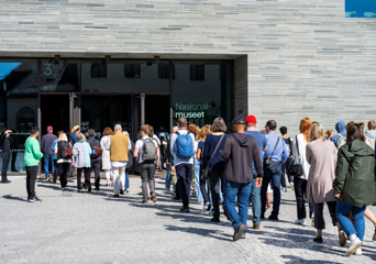 Mennesker i kø utenfor inngangen til Nasjonalmuseet i Oslo.