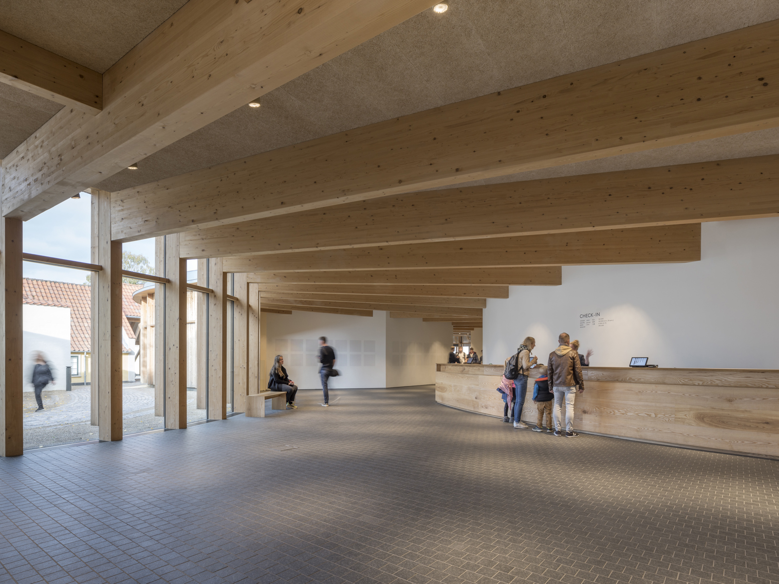 Interiørfoto av lobbyområde, synlig treramme konstruksjon. 