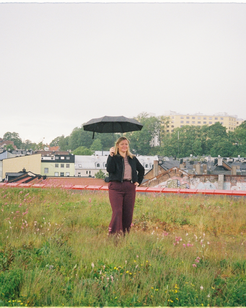 Foto av Kjersti Stenseng med en paraply i hånda på det grønne taket til Vega scene i Oslo.