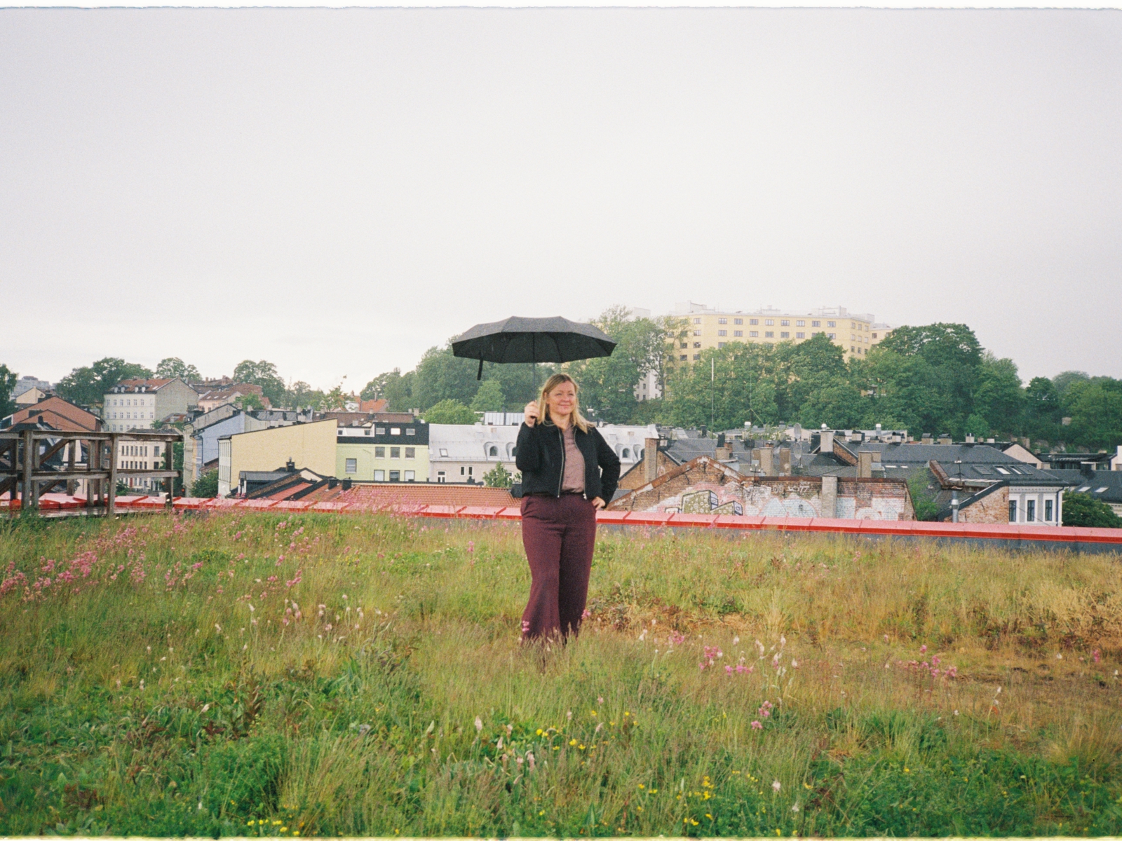 Foto av Kjersti Stenseng med en paraply i hånda på det grønne taket til Vega scene i Oslo.