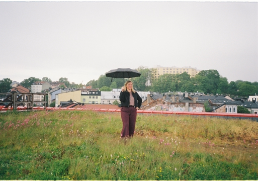 Foto av Kjersti Stenseng med en paraply i hånda på det grønne taket til Vega scene i Oslo.