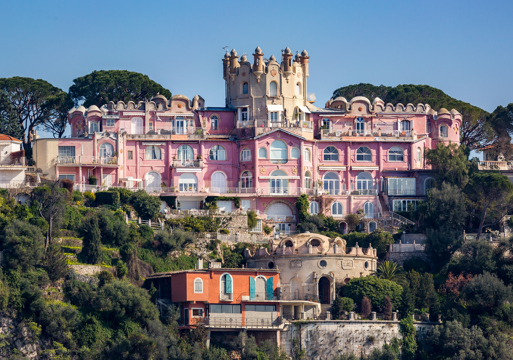 Bilde av et rosa bygg i solfylte Nice, Frankrike.