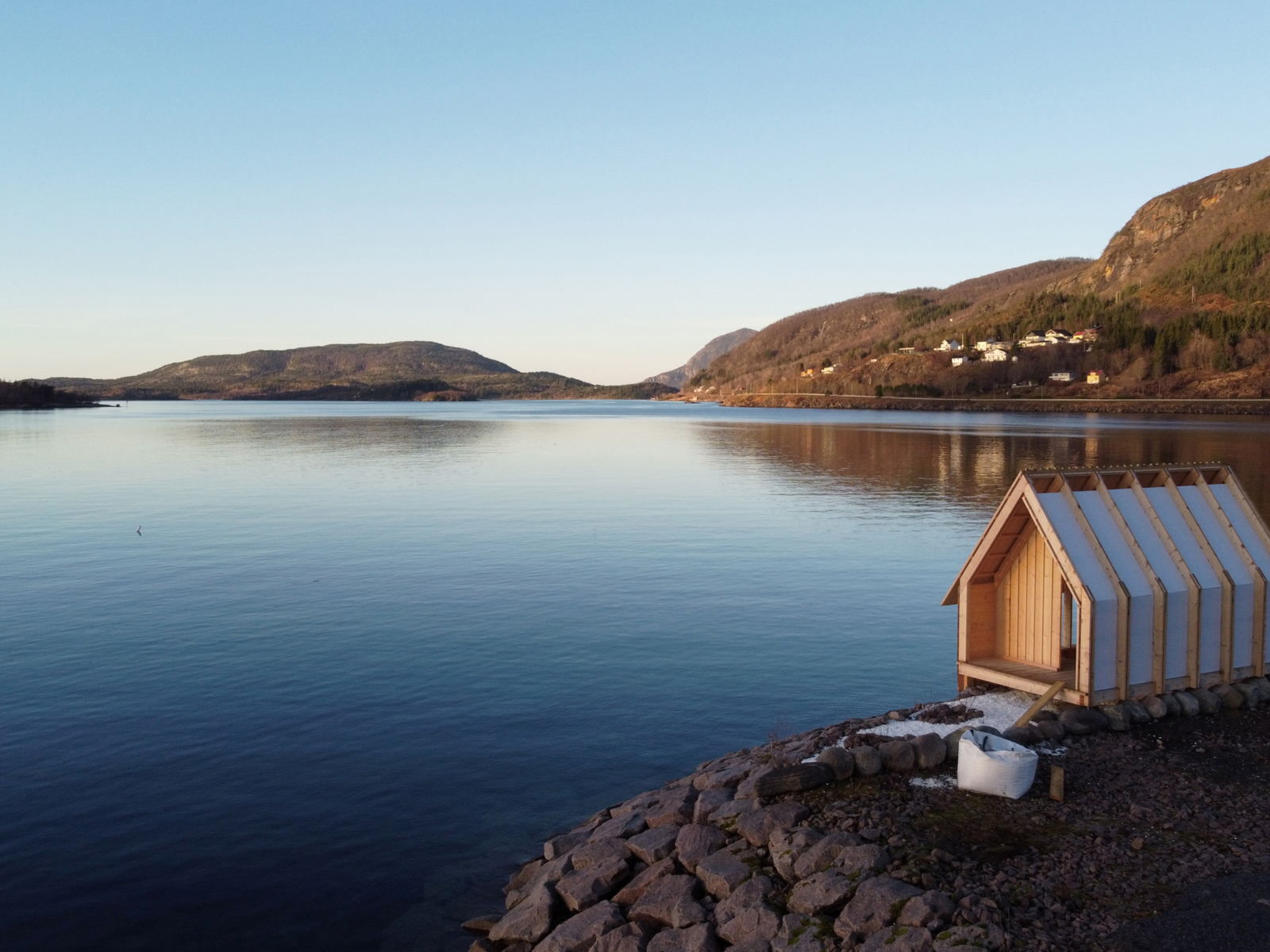 Et lite bygg ut mot en fjord