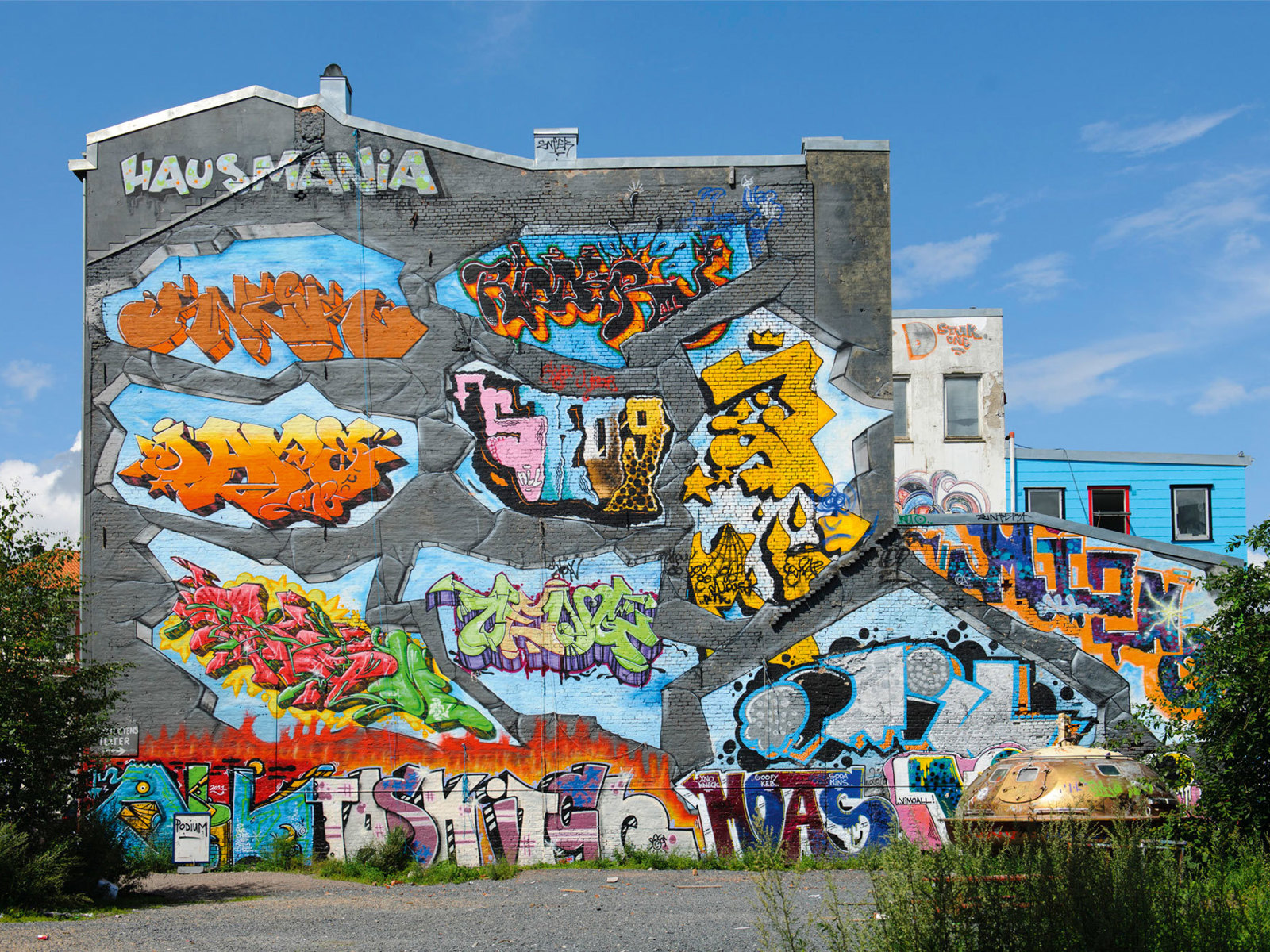 Gavl vegg på bygård fylt av graffiti. Foto.