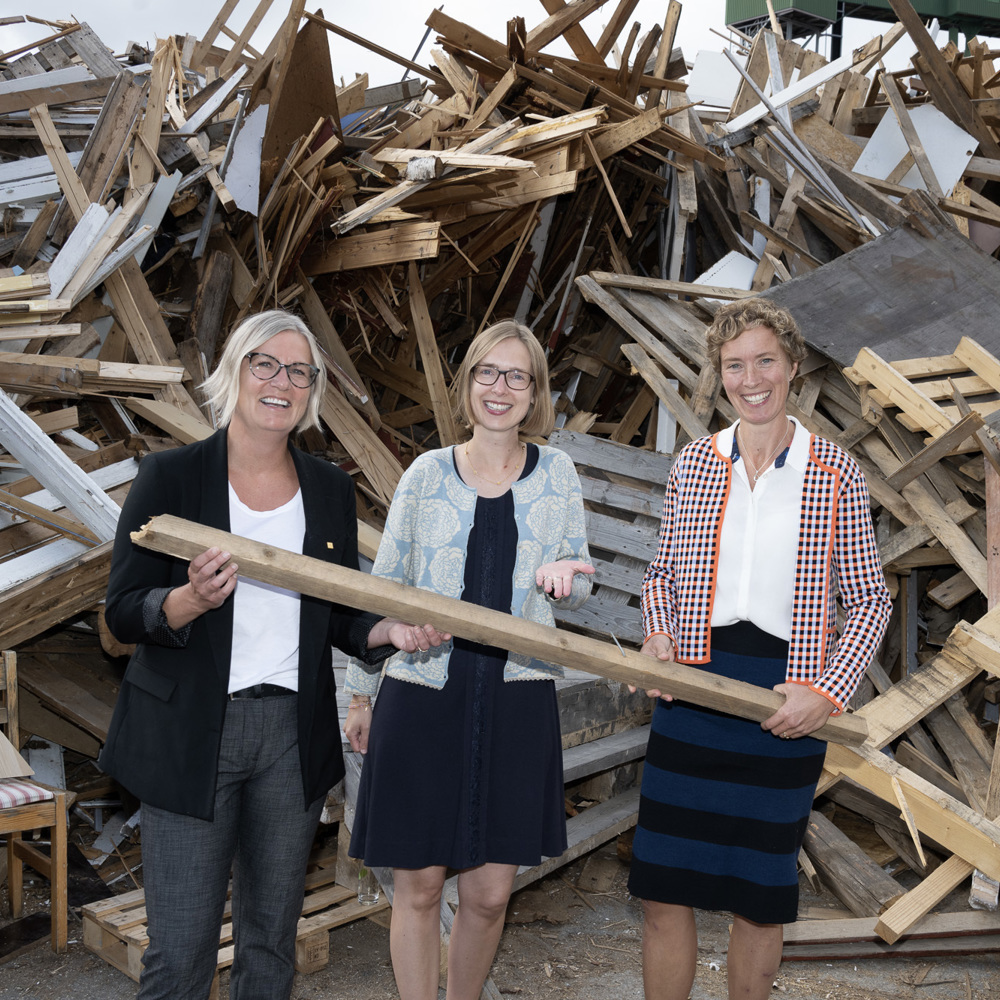 Foto av Kristin Nore, Iselin Nybø og Lone Ross foran en haug med gjenbruksmaterialer.