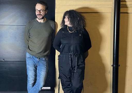 Dana Jdid og Nizam Najjar lener seg inntil en gul vegg. Foto.