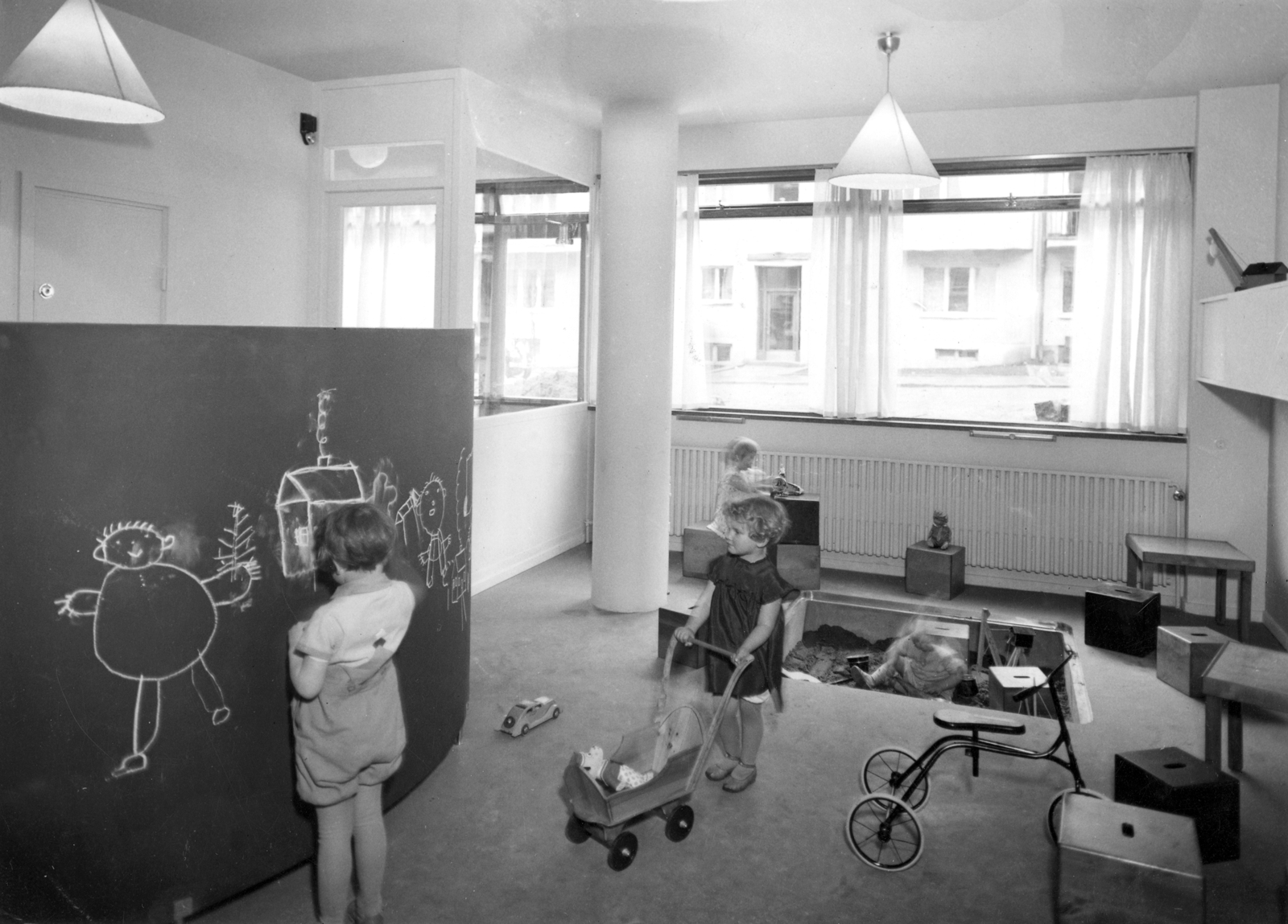 Interiør foto av lekerom, barn som leker. Svart hvitt foto.