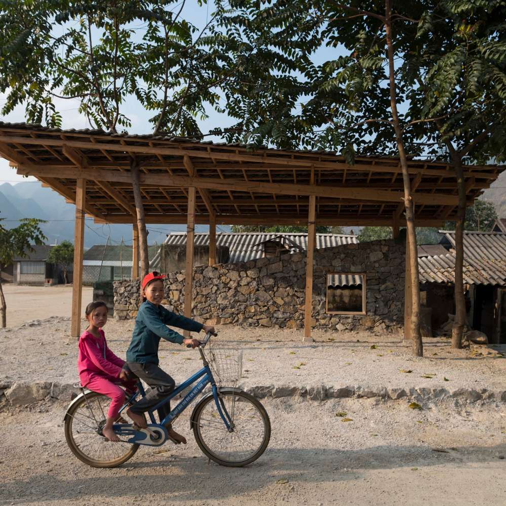 2 barn på en sykkel på landsbygda i Vietnam. Foto.