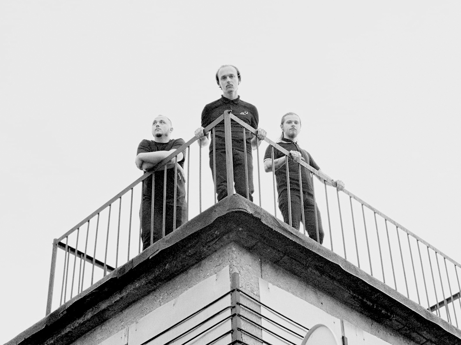 Tre personer som står på toppen av et hushjørne