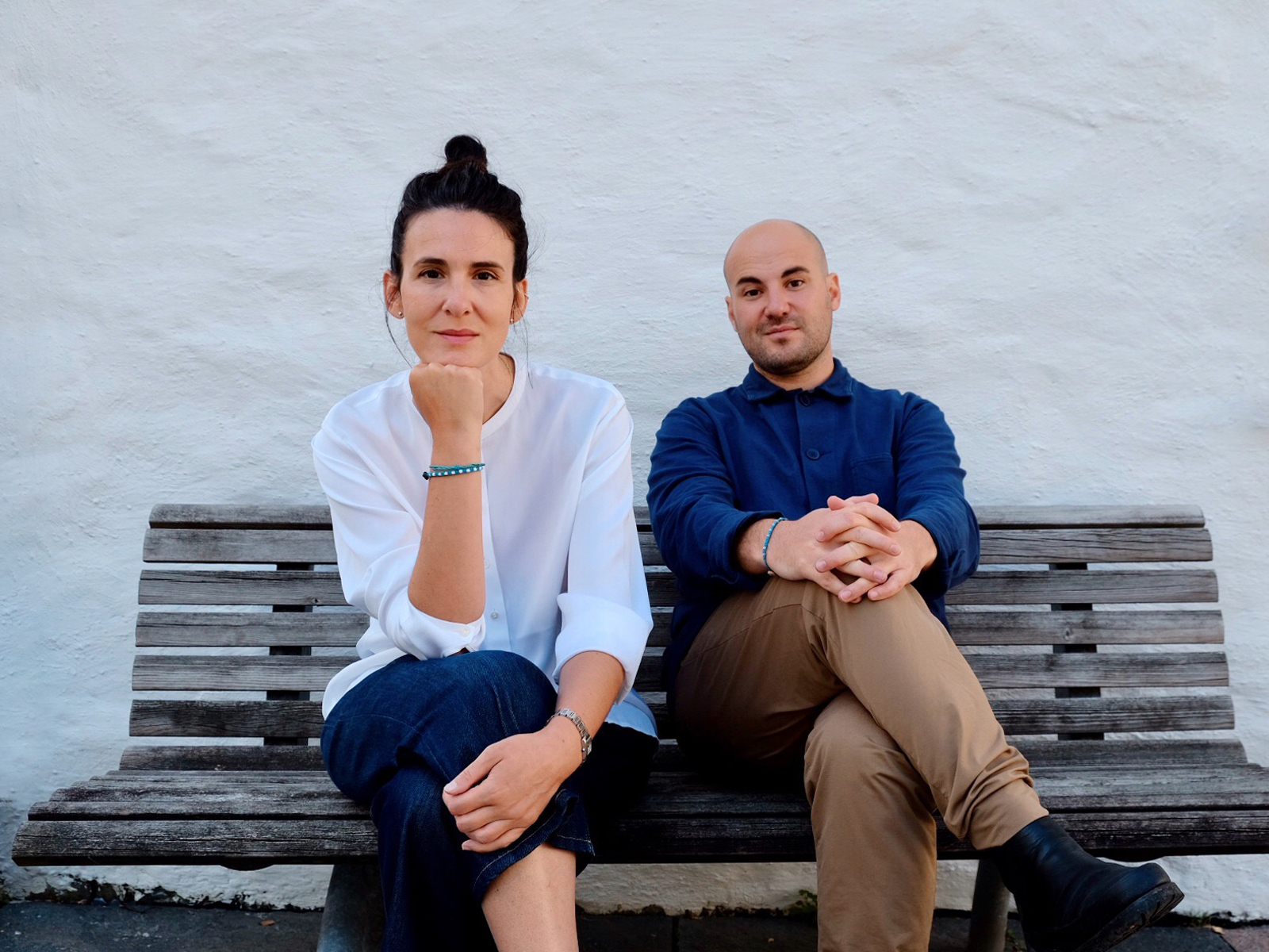Foto av Elida Mosquera og Jerome Picard som sitter fremoverlent på en benk.