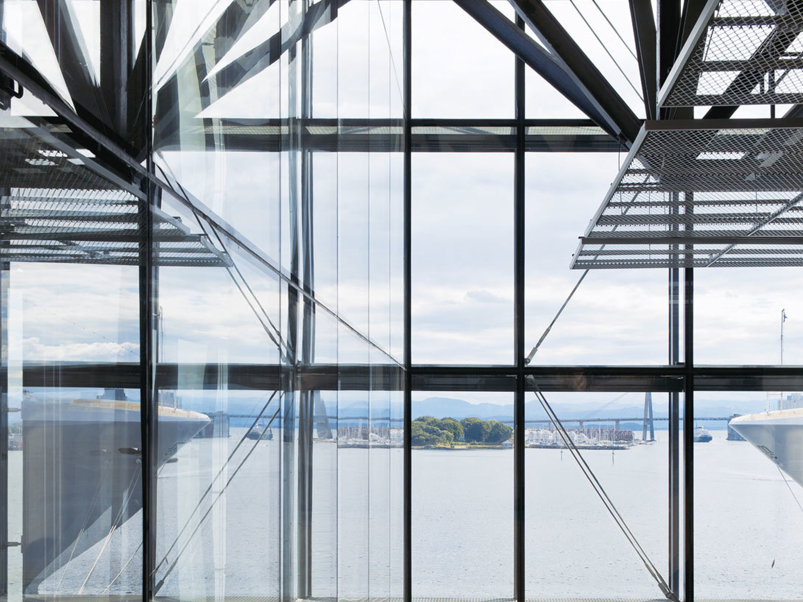 Foto av utsikt til havn ut gjennom glassfasade.