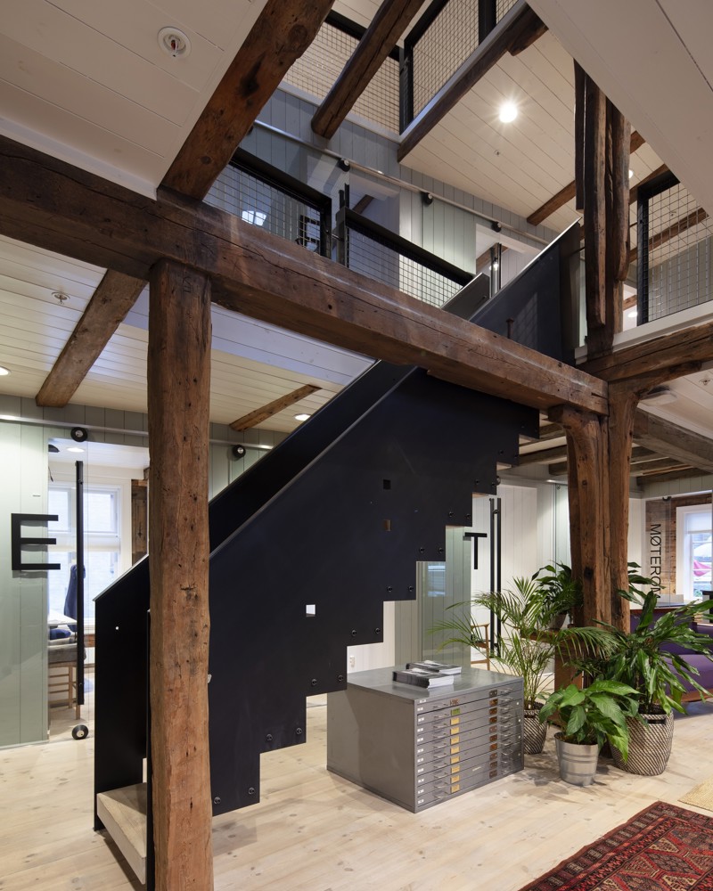 Et rom med trekonstruksjon og en trapp i stål