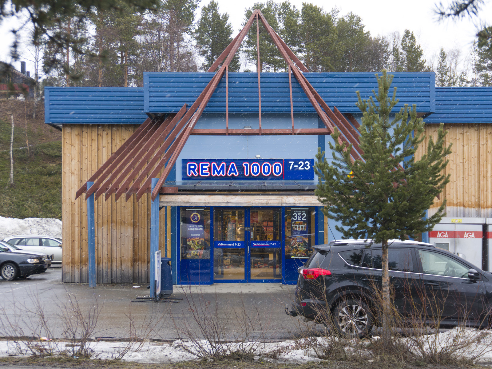 Foto av Rema 1000 butikk som har lavvo lignende former som inngangsparti.