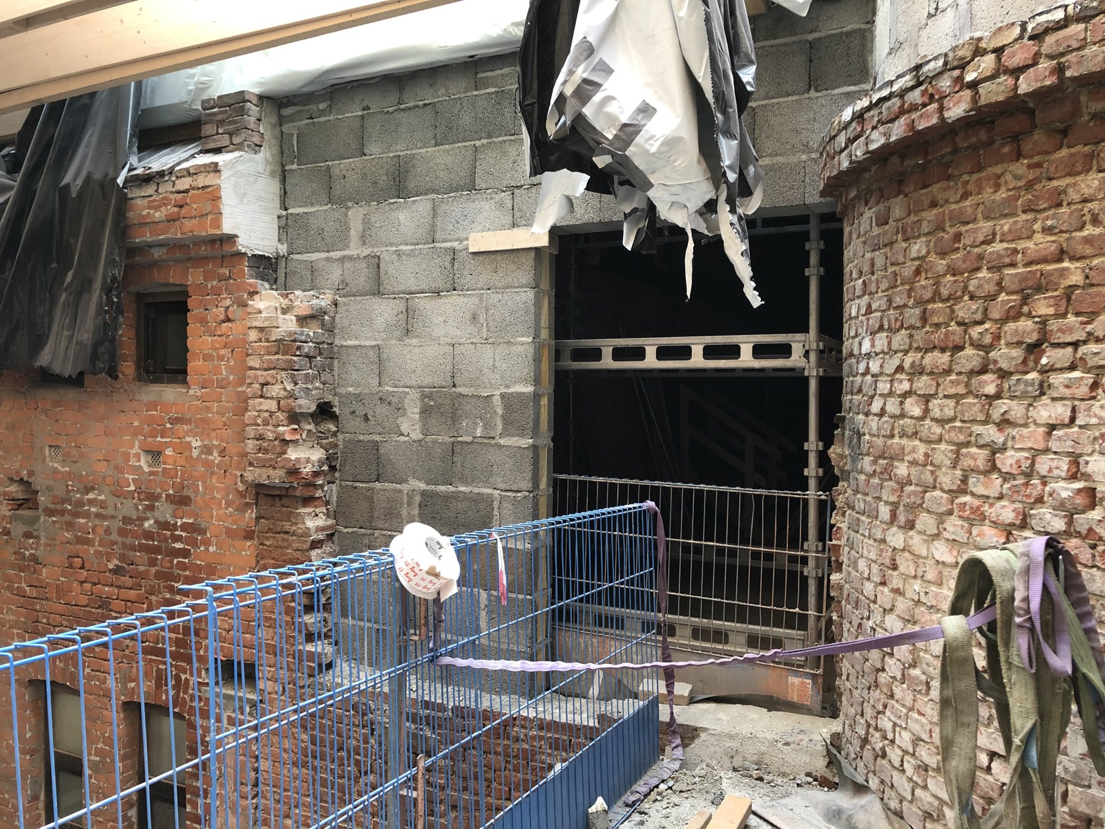 Gamle deler av bygg til syne under bygging, stilas. Foto.