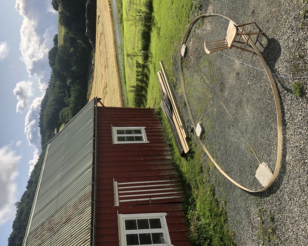 Foto av byggeprosess av en sirkel i treverk på et tun.